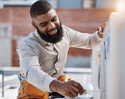 Building, engineer and air conditioner install with a black man on a roof for construction or manual labor. Industrial, engineering and an electrician working on ac repair for maintenance or service