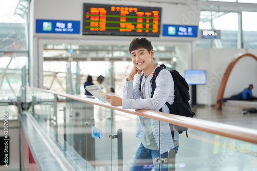 a young man holding a map at a train station photo