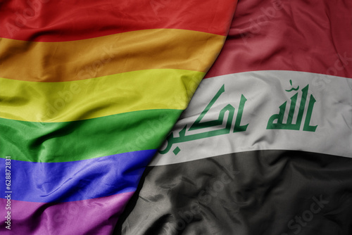 big waving realistic national colorful flag of iraq and rainbow gay pride flag .