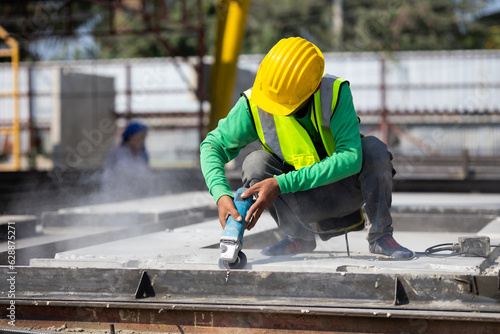 Labor man cutting steel at the construction site. Heavy Industry Manufacturing Factory. Prefabricated concrete walls. Asian worker wearing safety hardhat helmet