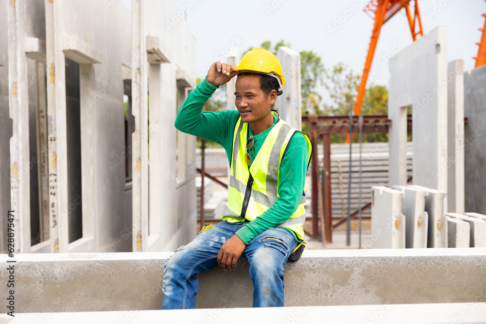 Tired hot wiping sweat. Asian worker enjoying free time. forman warehouse worker sitting on workshop site break relax time at Heavy Industry Manufacturing Prefabricated concrete walls Factory