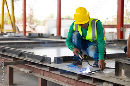 welding. Asian man worker weld metal with a arc welding machine at the construction site. Heavy Industry Manufacturing Factory. Prefabricated concrete walls