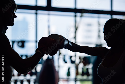 Silhouette shot of kickboxing enthusiasts routinely build strength, endurance, discipline at the gym photo