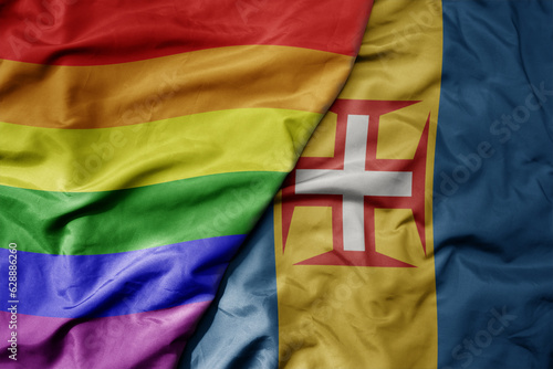 big waving realistic national colorful flag of madeira and rainbow gay pride flag .