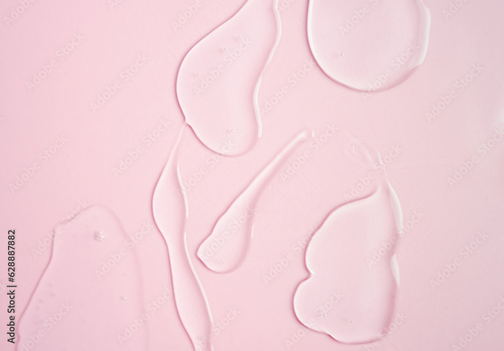 Obraz premium Samples of a transparent gel on a pink background. Texture of liquid cosmetic gel.