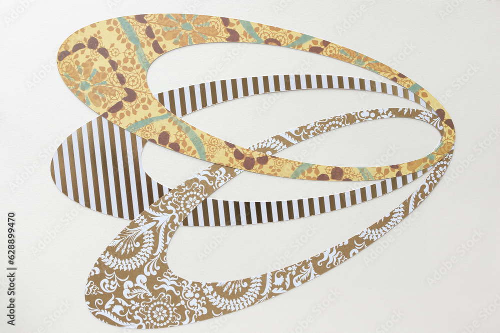 overlapping ovoid shapes machine-cut from scrapbooking paper and arranged on blank paper overlapping ovoid shapes machine-cut from scrapbooking paper and arranged on blank paper