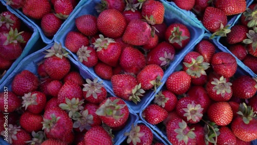 Display of fresh strawberries and cherries on display for sale at local farmers market.