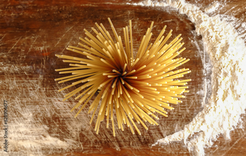 Włoski makaron Bucatini na drewnianym stole