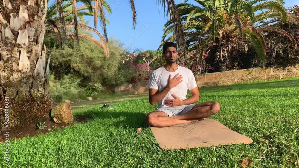 Joven indio practicando técnicas de respiración. Sesión sobre colchoneta de yoga en el parque. Relax al aire libre para una mejor salud. Ejercicios de enfoque por la mañana en verano en Tenerife
