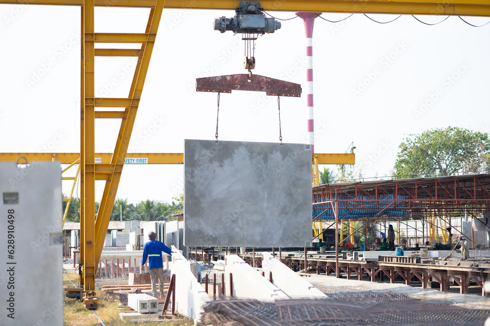 Naklejka premium Background banner. Large cranes moving prefabricated walls in factories. Prefabricated concrete walls for building office buildings and residential houses. reinforced concrete wall