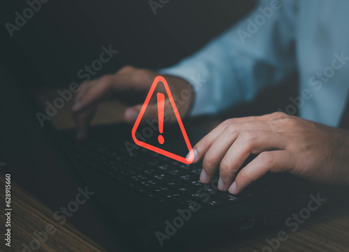 Obraz na płótnie Businessman or it staffs, programmer, developer using computer laptop with triangle caution warning sign for notification error and maintenance concept. Virus detected warning, Cybercrime protection w salonie