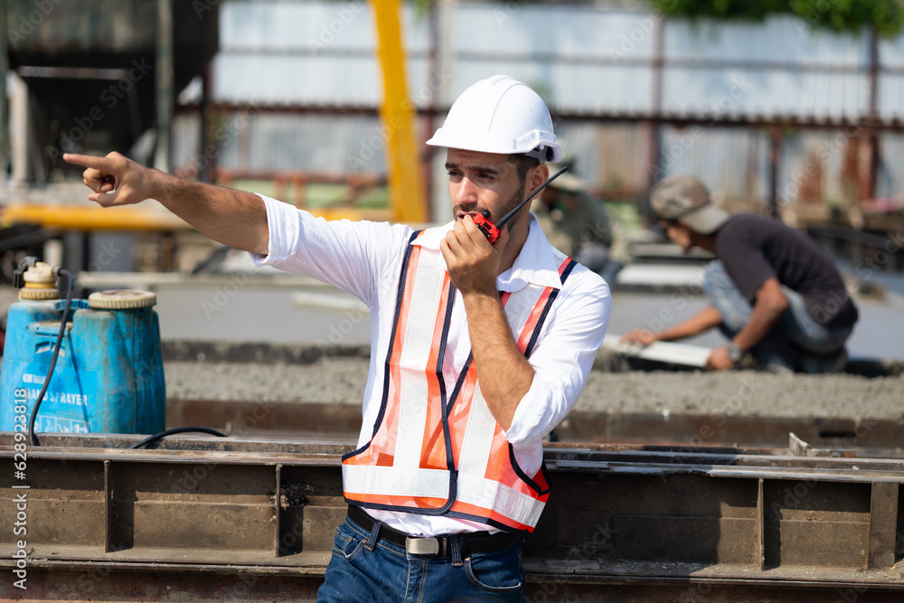radio transmitter. Hispanic latin architect construction Engineering man in hardhat talking on walkie talkie at factory facilities. Heavy Industry Manufacturing Factory. Prefabricated concrete walls radio transmitter. Hispanic latin architect construction Engineering man in hardhat talking on walkie talkie at factory facilities. Heavy Industry Manufacturing Factory. Prefabricated concrete walls