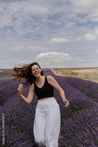 Beautiful Caucasian woman posing in a field of lavender flowers