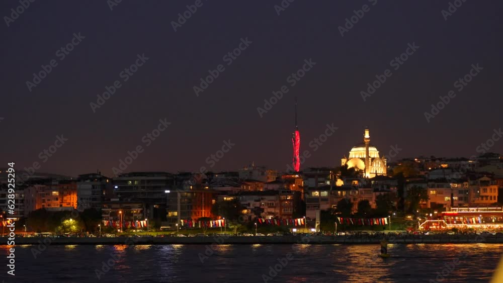 Night scene. View from a ferry on an illuminated asian side of Istanbul and the Camlica Tower at the background Night scene. View from a ferry on an illuminated asian side of Istanbul and the Camlica Tower at the background