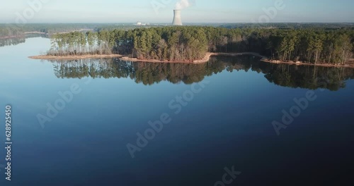 Drone footage over Harris Lake Park with trees and a coal power tower in distance in Wake County, NC photo
