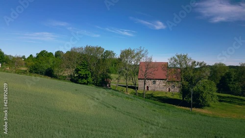 Raising drone over Berg Old Church (Berg steinkirke) with countryside fields in Larvik, Norway photo