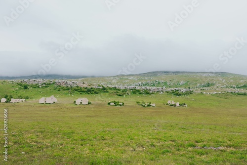 Vast grassy field set against a backdrop of cloudy sky