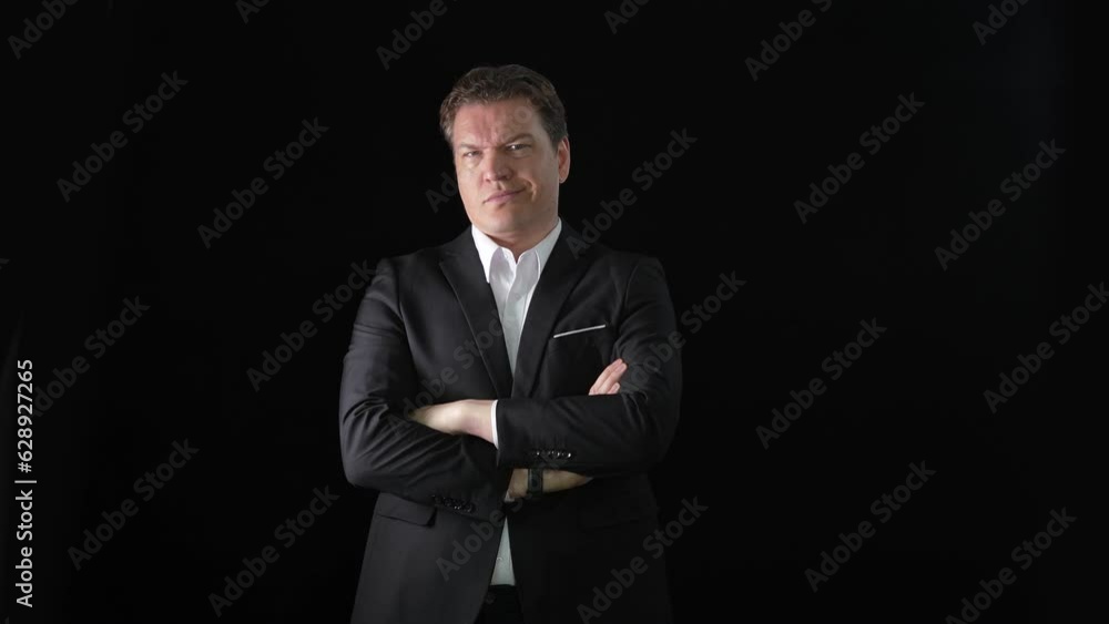 Strong serious businessman crossing his arms and shaking his head in denial on a black background