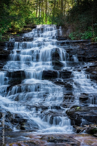 a large waterfall in the middle of trees in the mountains