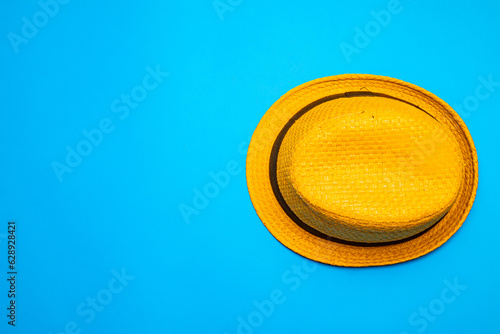 Top view of straw hat over blue background. Flat lay top-down compositiont. Minimalist flat lay photo of straw hat with copy space. photo