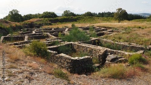 castro romano de la edad de hierro en el pueblo de castromaior, viviendas cuadradas y rectangulares de piedra y pequeñas callejuelas, al fondo la muralla interna, lugo, galicia, españa, europa photo