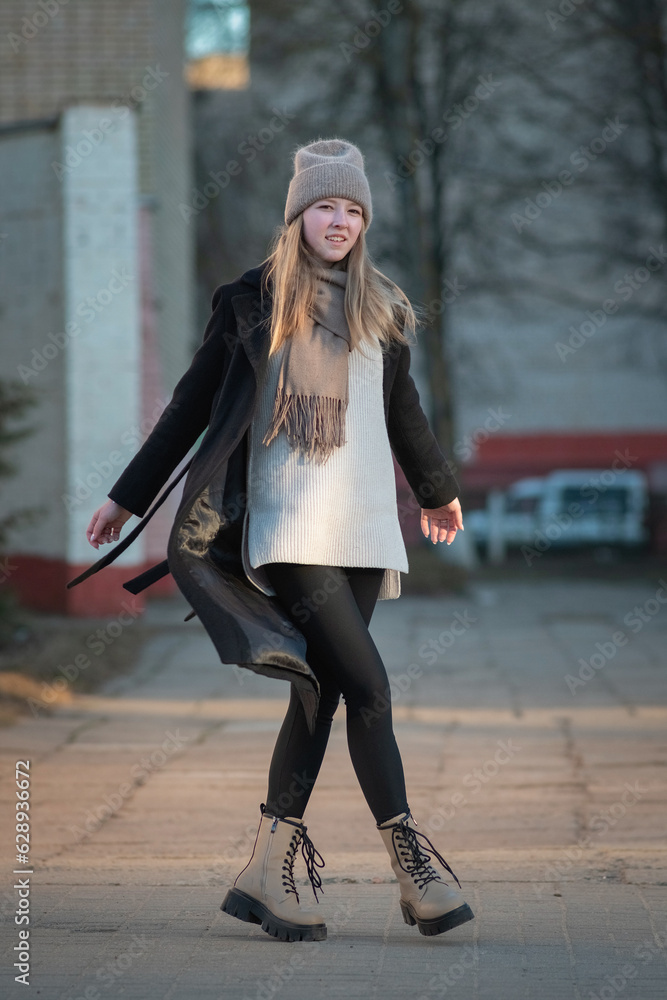 Portrait of a beautiful young girl in a black coat and gray hat. Portrait of a beautiful young girl in a black coat and gray hat.