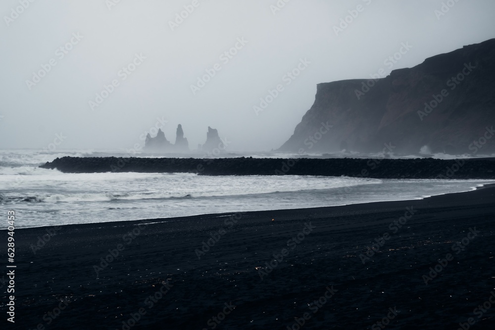 Idyllic beach scene in Reykjavik, Iceland featuring black sand and a foggy weather Idyllic beach scene in Reykjavik, Iceland featuring black sand and a foggy weather