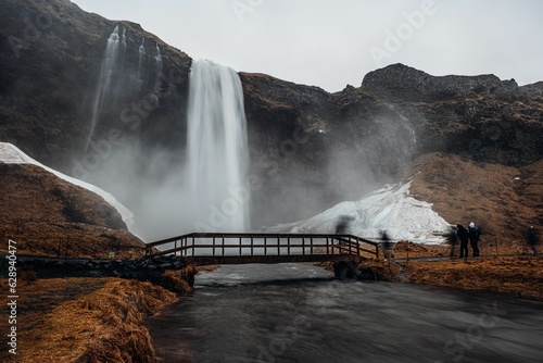 cascading waterfall amidst a winter wonderland of snow and grass  in Reykjavik  Iceland