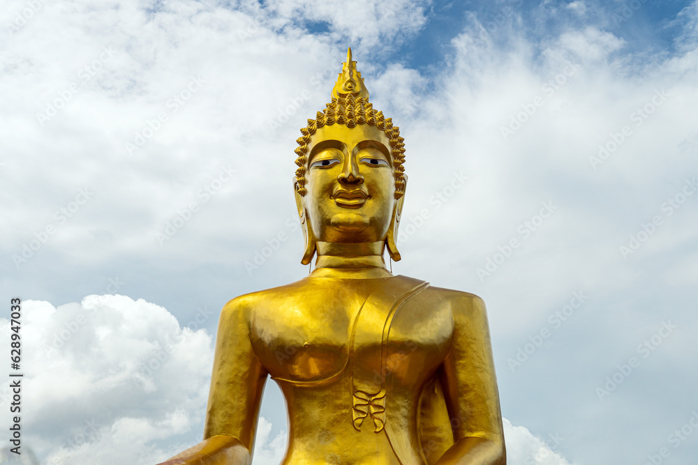 Big golden buddha statue on mountain with cloud in morning Pattaya Thailand.