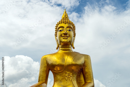 Big golden buddha statue on mountain with cloud in morning Pattaya Thailand.