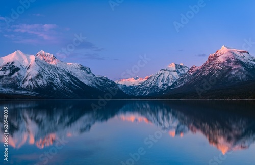 Canvas Print Early morning sunrise illuminating serene waters of Lake McDonald, Glacier Natio