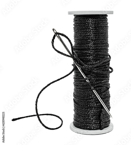 Plastic spool with black synthetic threads close-up. Needle and thread