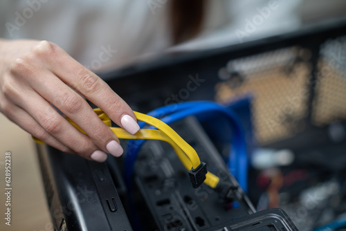 Close-up of a woman's hand holding computer cables