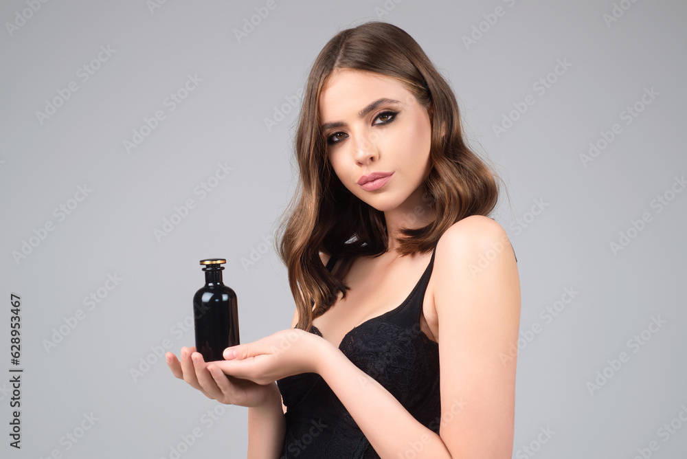 Young pretty woman smelling perfume. Sensual woman with bottle of perfume, beauty portrait. Female perfume, fragrance. Girl holding up bottle of perfumery. Luxury perfume. Adv for perfumes store. Young pretty woman smelling perfume. Sensual woman with bottle of perfume, beauty portrait. Female perfume, fragrance. Girl holding up bottle of perfumery. Luxury perfume. Adv for perfumes store.