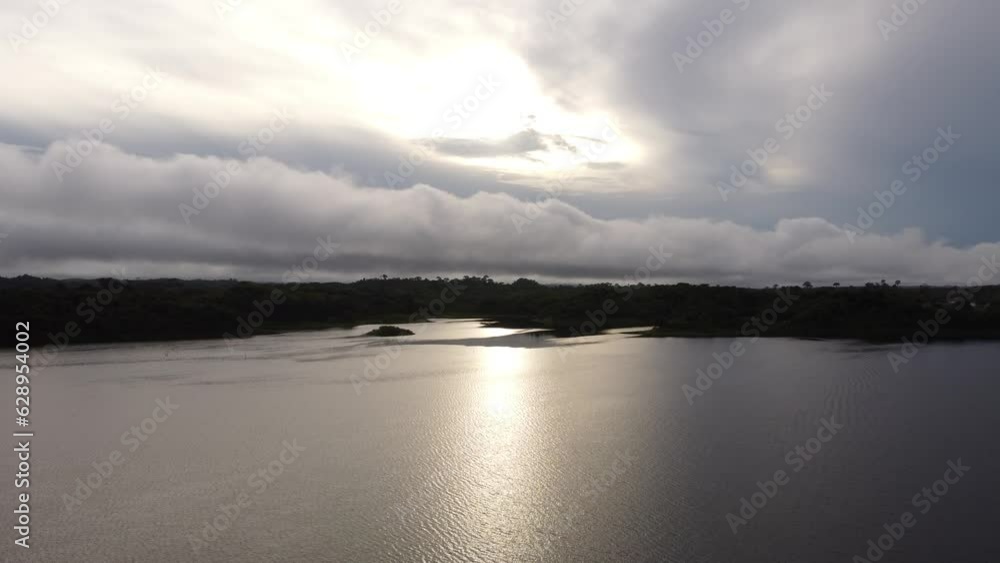 Aerial of a small island on the river under the cloudy sky during the sunset Aerial of a small island on the river under the cloudy sky during the sunset