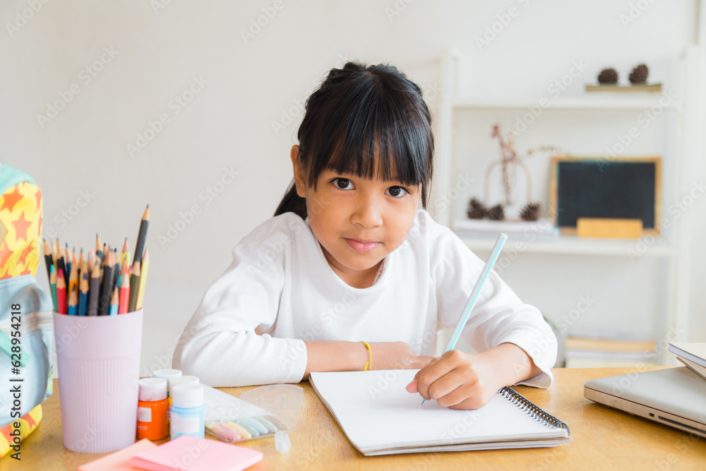 A girl coming home from school is sitting and doing her homework in the living room. A girl coming home from school is sitting and doing her homework in the living room.
