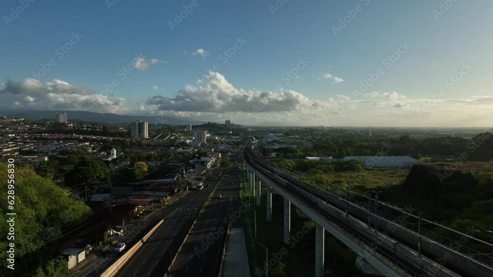 Aerial video of a road and a bridge surrounded by the city and a green field Aerial video of a road and a bridge surrounded by the city and a green field
