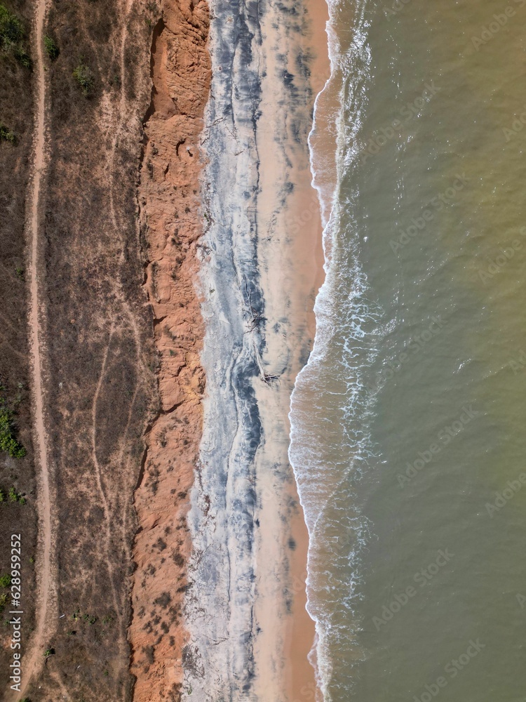 Aerial view of the rocky beach surrounded by the sea on a sunny day Aerial view of the rocky beach surrounded by the sea on a sunny day