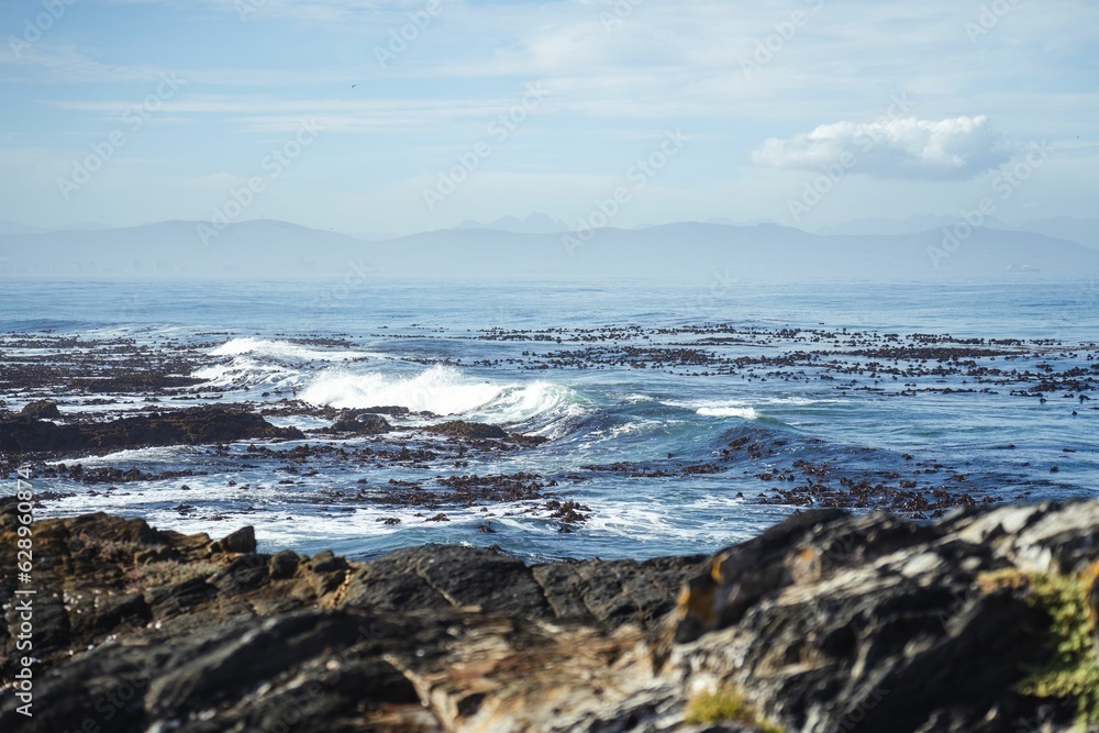 the ocean waves breaking at low tide on a cloudy day