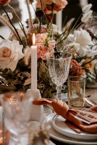 an elegantly decorated table is displayed with a candle and flowers