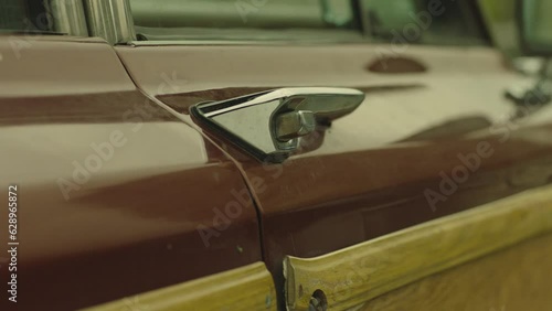Close-up of car door with old chrome handle. Man's hand with black gloves closing or opening door . Man opens the driver's seat door . American vintage suv Jeep Wagoneer . Concept of robbery or theft