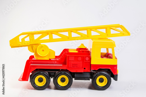 Multi-colored plastic toy trucks for children's games on a white background. Fire truck with telescopic antenna. © baxys