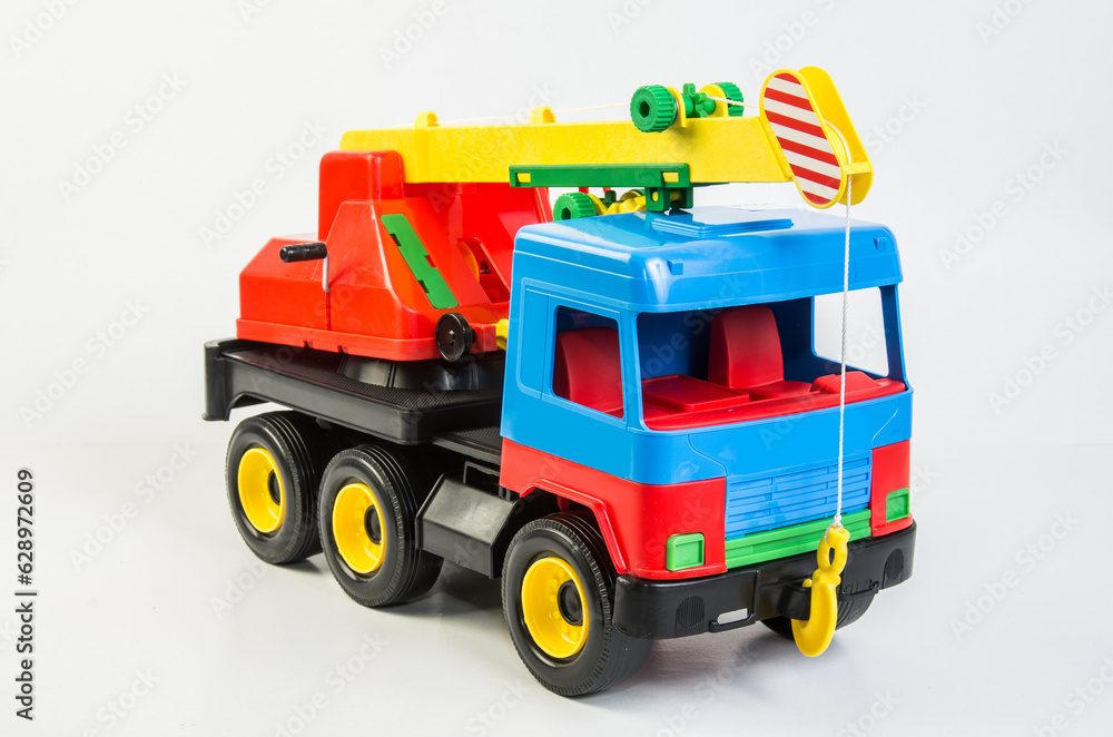 Fototapeta premium Multi-colored plastic toy trucks for children's games on a white background. Truck crane.