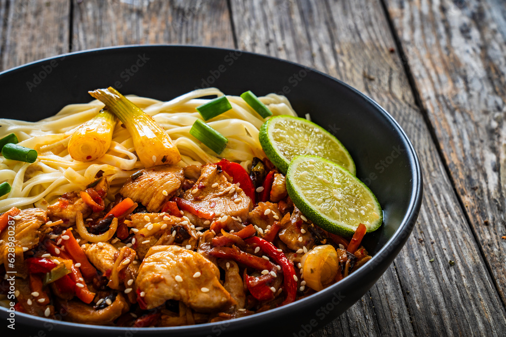 Asian food - chicken nuggets, noodles and stir fried vegetables on wooden table
Asian food - chicken nuggets, noodles and stir fried vegetables on wooden table