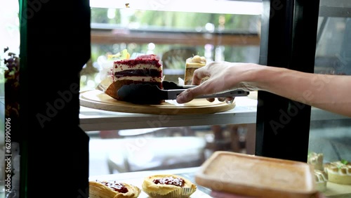 4k, close-up hands unrecognizable female employee holding red velvet cake bakery put on wooden plate to serve customer on table,  lifestyle young Asian barista or coffee shop owner working concept