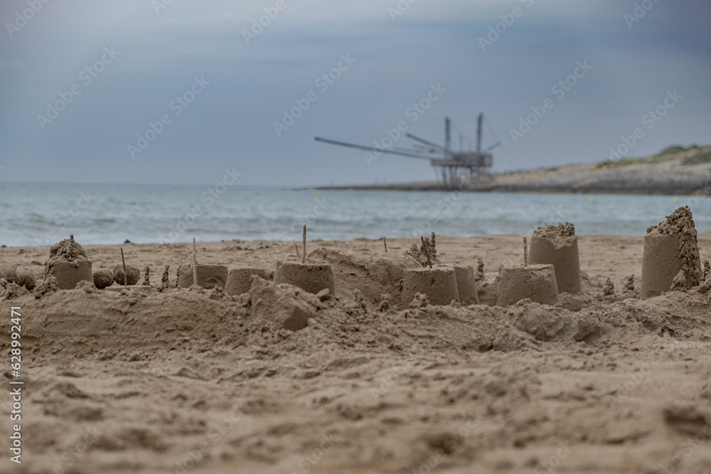 Castles made of sand with italian 'Trabucco' structure in background