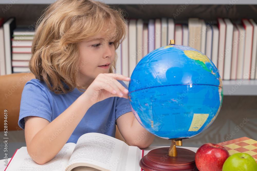 Cute pupil looking at globe in library at the elementary school. School child. Kid boy from elementary school. Pupil go study. Clever schoolboy learning. Kids study, knowledge and education. Cute pupil looking at globe in library at the elementary school. School child. Kid boy from elementary school. Pupil go study. Clever schoolboy learning. Kids study, knowledge and education.