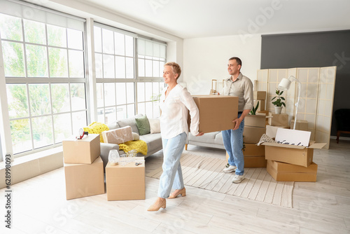 Mature couple carrying cardboard box in room on moving day © Pixel-Shot