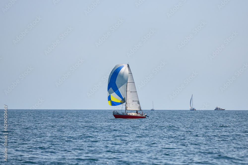 Sailing yacht regatta. Many sailing yachts in a row. sailing yachts under gennaker, speaker, genoa Sailing yacht regatta. Many sailing yachts in a row. sailing yachts under gennaker, speaker, genoa