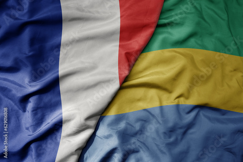 big waving realistic national colorful flag of france and national flag of gabon .